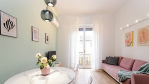 A living room with a round table, a sofa, and artwork on the walls. - VivimiHome - La Stella dei Navigli (Milan)