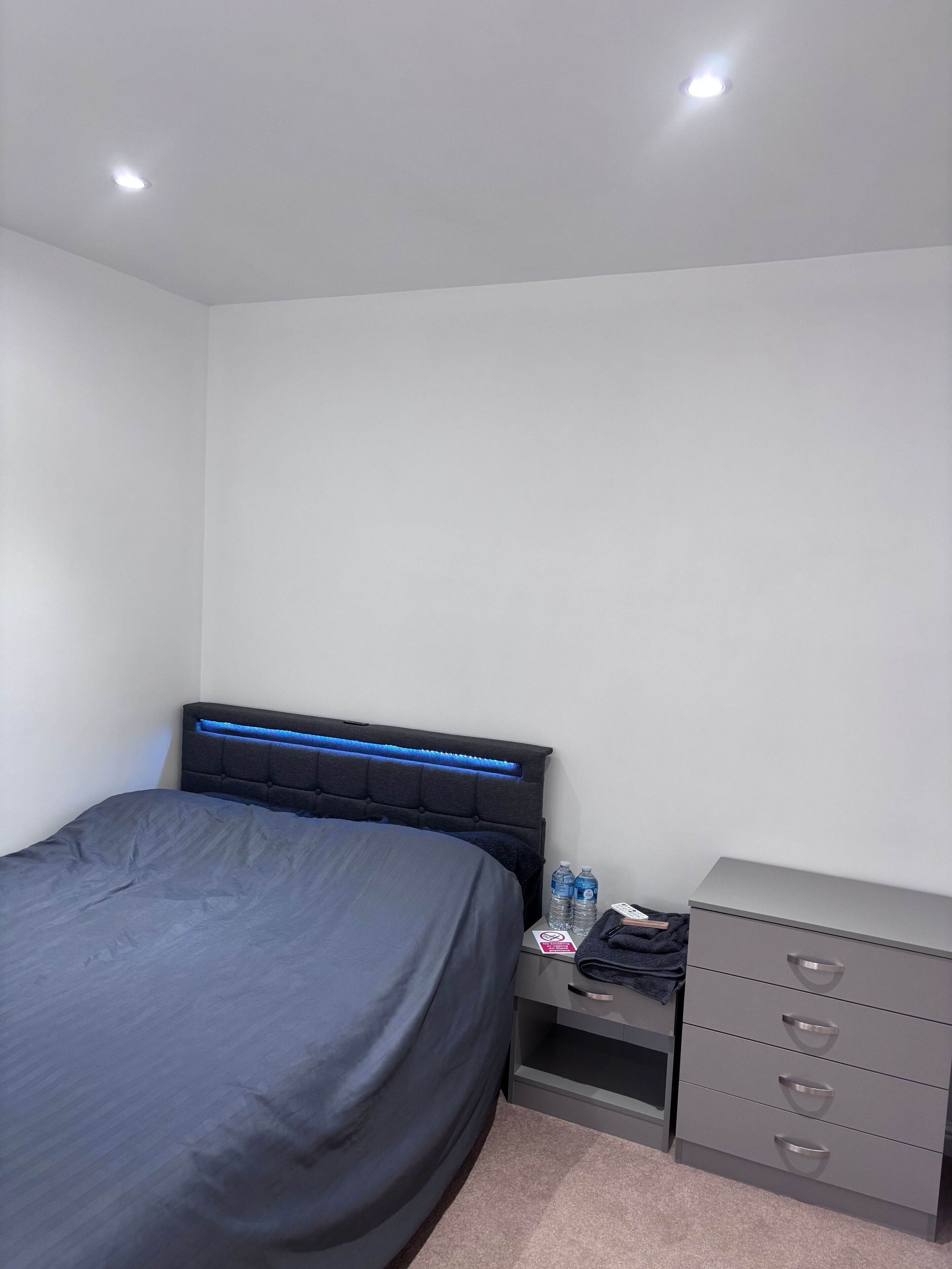 Ein Schlafzimmer mit Bett, Nachttisch und Kommode.