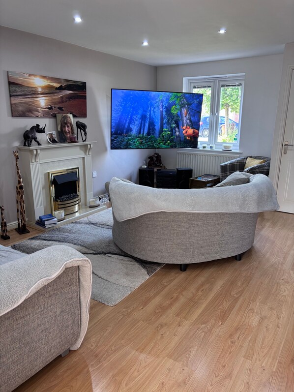 A living room with a fireplace, a flat-screen TV, and a sofa.