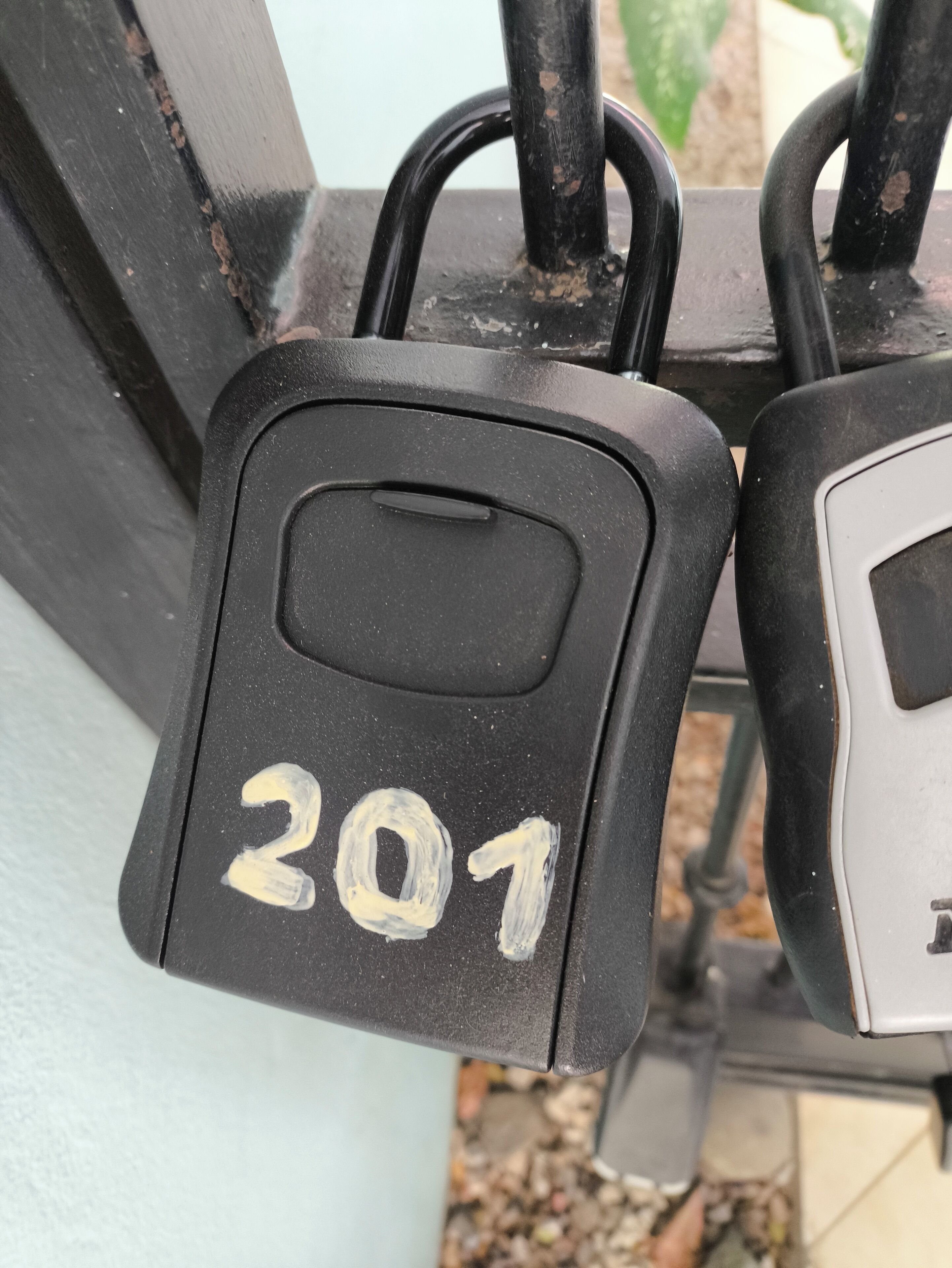 A padlock with the number 201 on a metal gate.