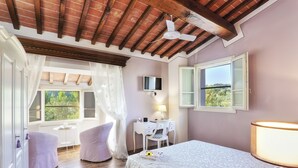 A bedroom with a bed, a desk, a chair, a TV, and a window with a view. - Wonderful Family Suite in Tuscany near Pisa and Florence - 2 Bedrooms 4 PL (Palaia)