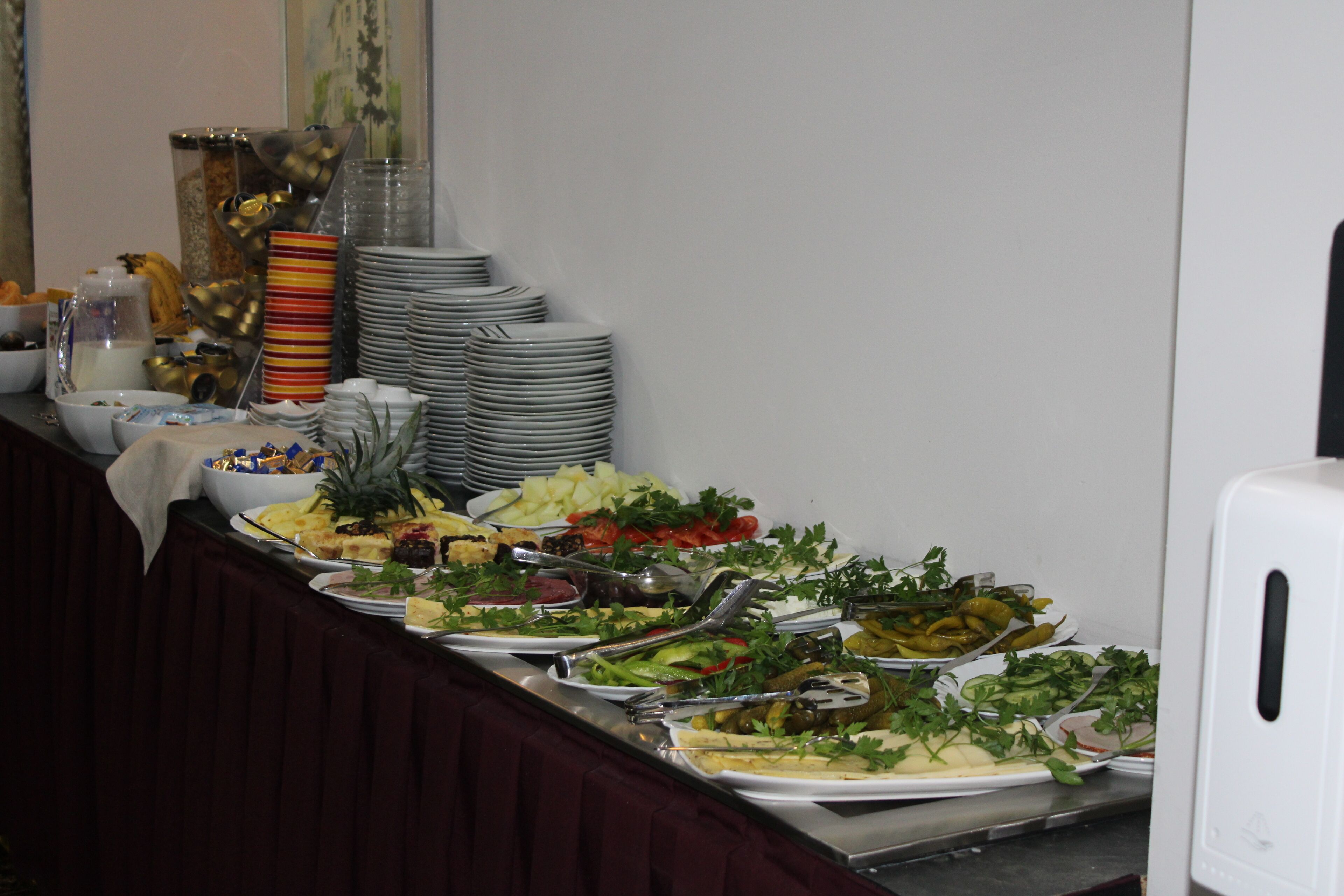 A buffet with various food items and utensils.