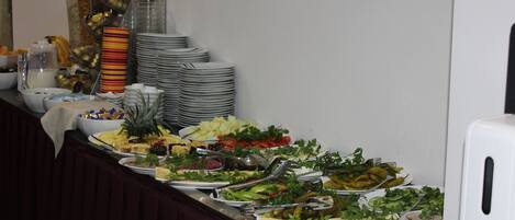 A buffet with various food items and utensils.