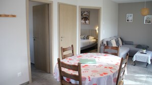 A room with a dining table, chairs, a sofa, and a bed. - Comfortable 44 M2 house, 3* Gîte de France, 100 m from stock pond. (Kerprich-aux-Bois)
