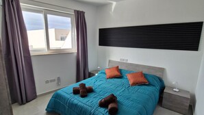 A modern bedroom with a bed, curtains, a nightstand, and a ceiling fan. - Penthouse Penthouse Green House A27 - Green style (Saint Paul's Bay)