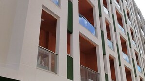 Een meerlaags gebouw met balkons, ramen en een groene gevel.