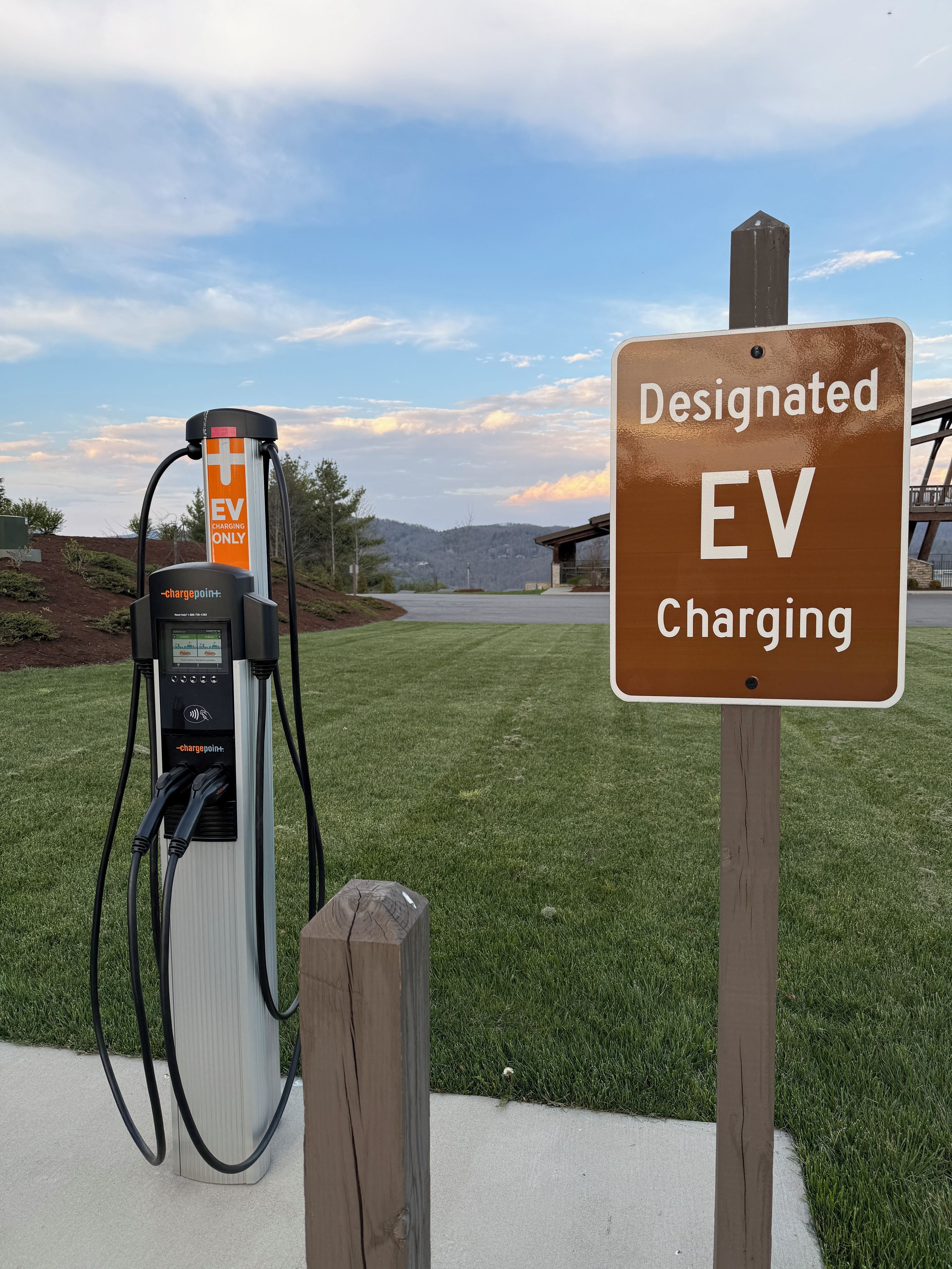 Una estación de carga para vehículos eléctricos, con un cartel que indica que es un punto de carga designado.