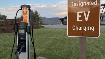 Una estación de carga para vehículos eléctricos, con un cartel que indica que es un punto de carga designado.