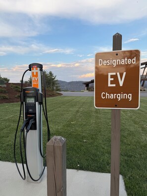 An EV charging station with a sign indicating it is a designated EV charging spot. - 1BR Condo w/ Stunning Long-Range Views, Deck + Hot Tub / Pool / Gym - Near Boone (Boone)