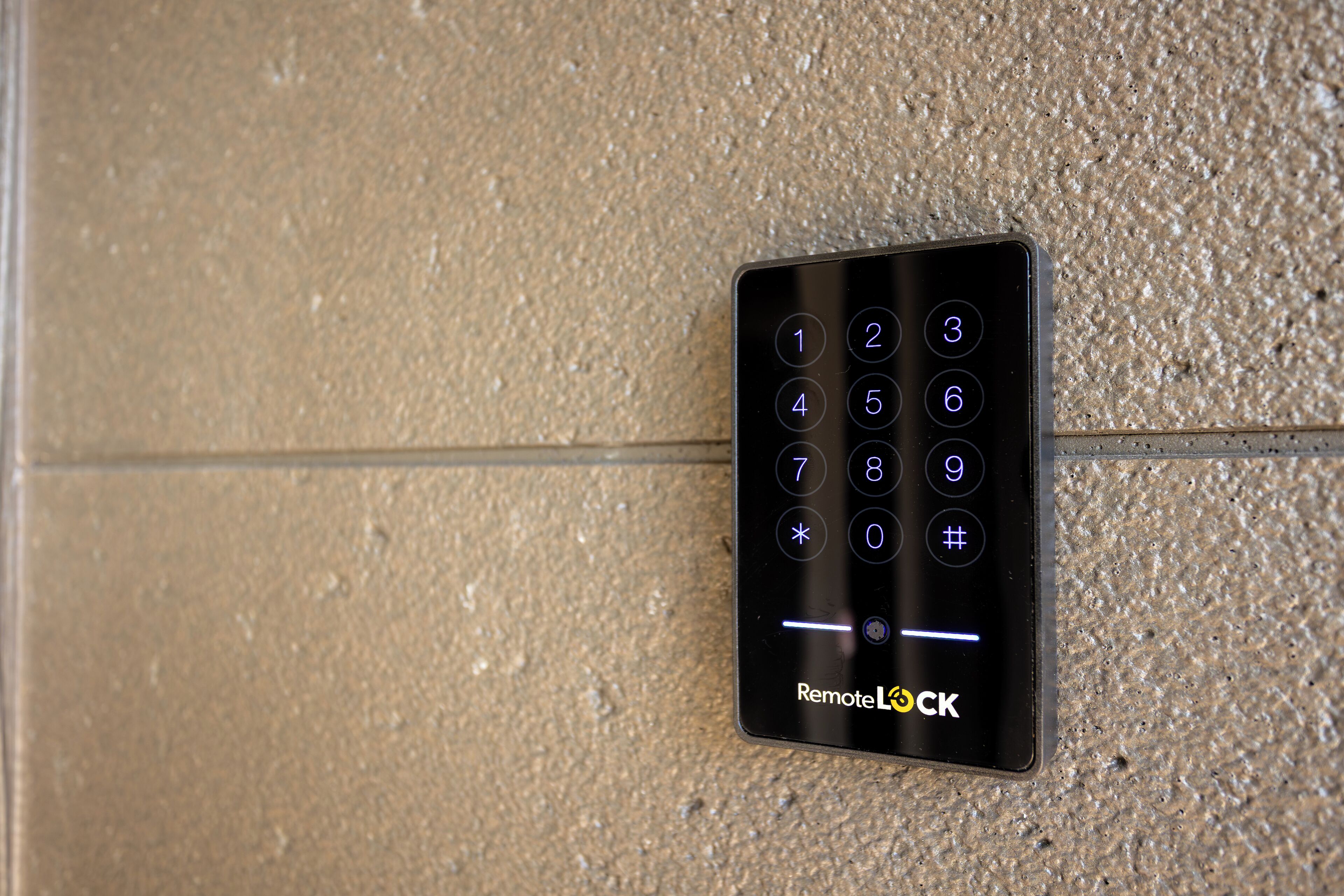 A wall-mounted remote lock keypad with a textured background.