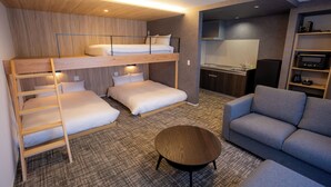 A bunk bed room with a sofa and a round table. - THE NINE STATES HOTEL TOJINMACHI (Fukuoka)