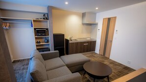 A compact living space with a sofa, a small table, a kitchenette, and a wardrobe. - THE NINE STATES HOTEL TOJINMACHI (Fukuoka)