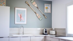 A kitchen with a white countertop, a sink, a toaster, and two wooden paddles on the wall. - Picturesque Lakeview Holiday House for 6 (Lacanau)