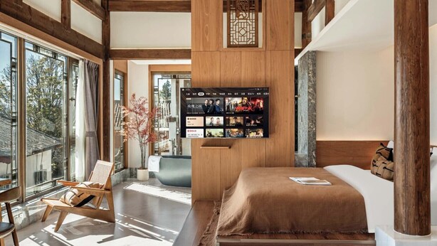 A modern hotel room with a large bed, wooden beams, a TV wall, and a view of the outdoors. - Zome Yunju· Skyview Villa, Lijiang Old Town (Lijiang)