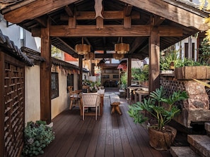 A covered patio with wooden furniture, hanging lamps, and potted plants. - Zome Yunju· Skyview Villa, Lijiang Old Town (Lijiang)