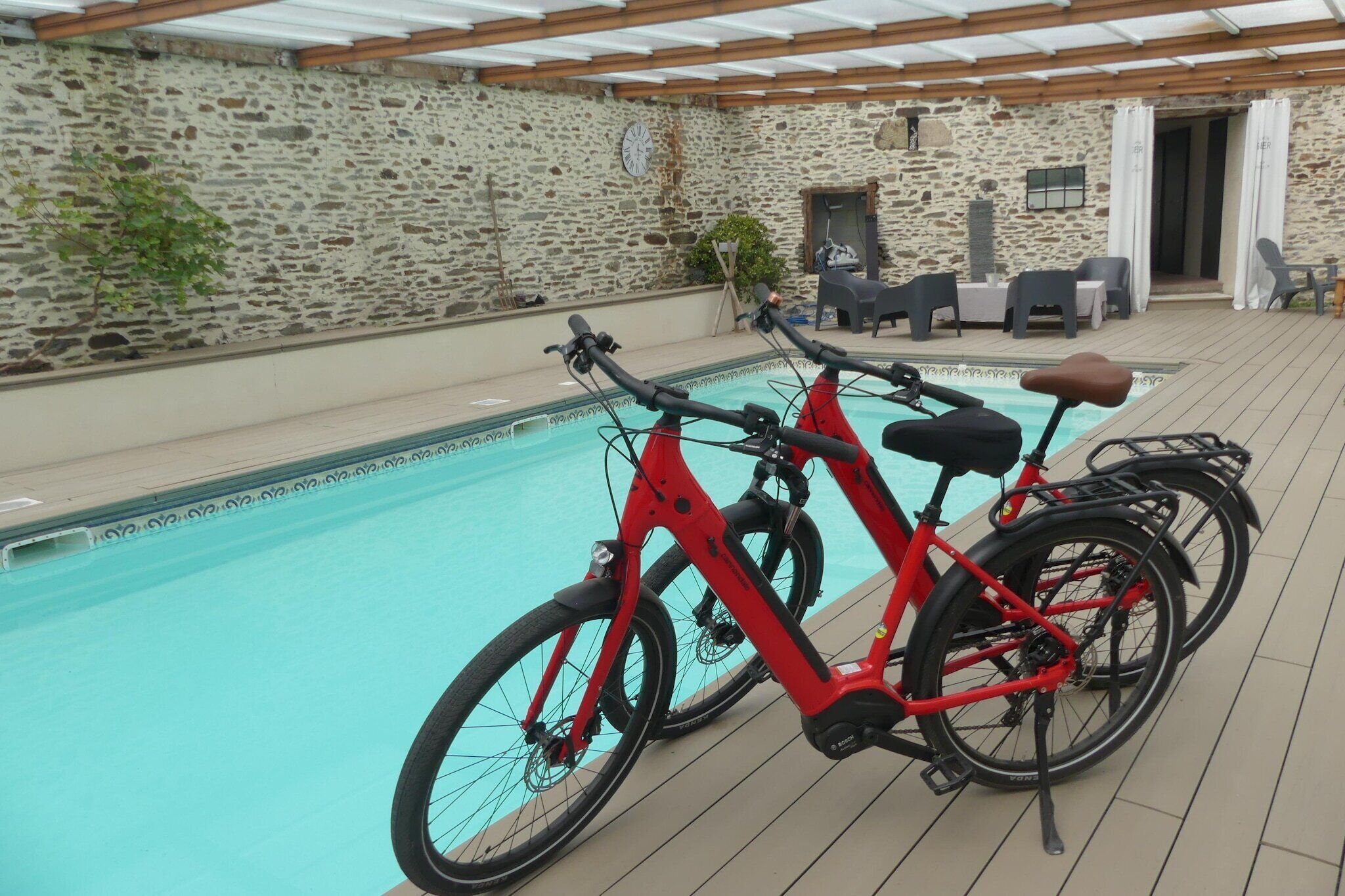 Ein Poolbereich mit Steinmauern und zwei roten Fahrrädern.