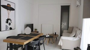 Una sala moderna con comedor, un sofá, una mesa de centro y un radiador.