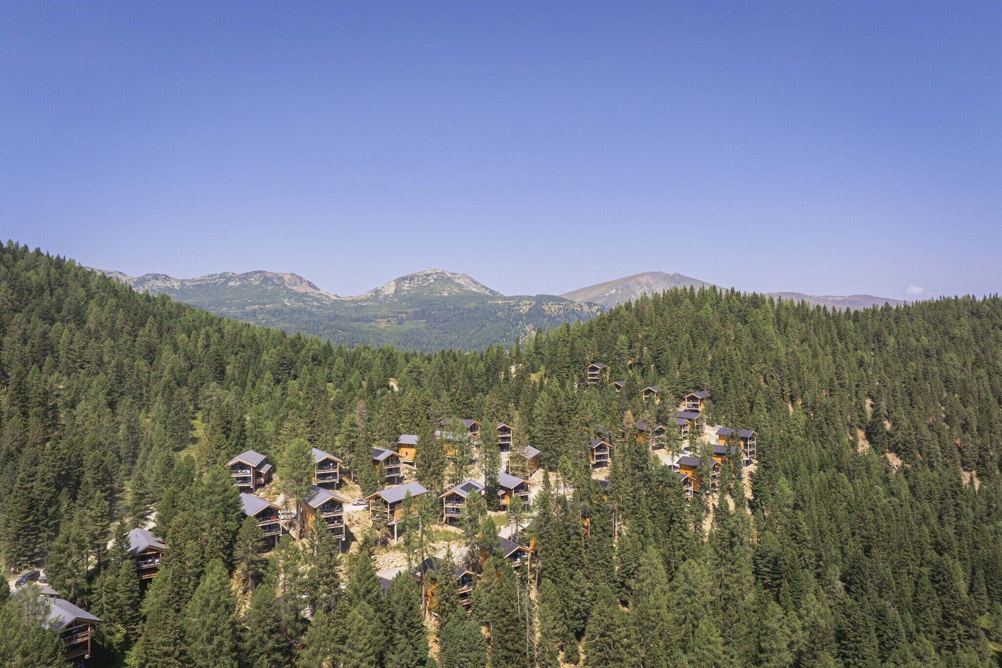 Zones de muntanya boscanes amb diverses cabanes.