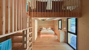 A wooden interior with a bunk bed, a desk, and a large window. - Deluxe chalet with sauna & hot tub (Turrach)