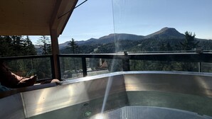 A hot tub with a view of mountains and trees. - Deluxe chalet with sauna & hot tub (Turrach)