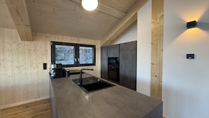 Una cocina moderna con una isla grande, electrodomésticos integrados y un ventanal con vistas.