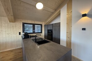 Eine moderne Küche mit einer großen Kochinsel, integrierten Geräten und einem Fenster mit Blick.