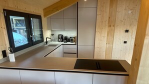 Une cuisine moderne dotée d’une grande fenêtre, de meubles encastrés et d’un îlot central.