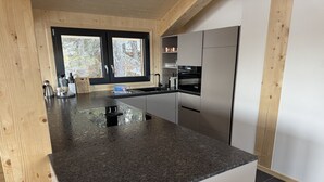 Uma cozinha moderna com bancadas de granito, eletrodomésticos de aço inoxidável e armários de madeira.