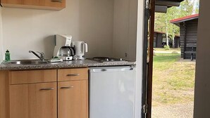 Une cuisine de taille réduite équipée d’un lave-vaisselle, d’une machine à café et d’un évier.