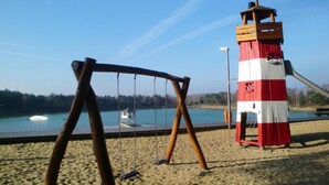 Une plage avec une balançoire et un poste de surveillance des sauveteurs rouge et blanc.