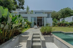 A modern house with a pool, steps leading to the entrance, and lush greenery. - Staymaster Casa Tanisa 3BR Pool (Vagator)