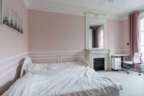 A bedroom with a bed, a desk, a chair, a fireplace, and a mirror. - Bright And Spacious 3BDR Apt Near Eiffel Tower (Paris)