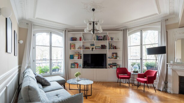 A living room with a sofa, a TV, a fireplace, and a bookshelf. - Bright And Spacious 3BDR Apt Near Eiffel Tower (Paris)