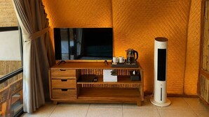 A room with a television on a wooden stand, a white air purifier, and a small table with a kettle and cups. - LuxCamp Pangalengan By Horison (Pangalengan)