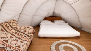 A tent-like room with a bed and a couch. - LuxCamp Pangalengan By Horison (Pangalengan)