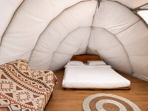 A tent-like room with a bed and a couch. - LuxCamp Pangalengan By Horison (Pangalengan)