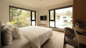 Ein Schlafzimmer mit Bett, Schreibtisch, Stuhl und Fernseher.