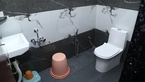 A bathroom with a sink, toilet, and shower. - JMC HOTEL KIA INN (Pithampur)