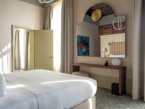 A hotel room with a bed, a desk, a mirror, and a painting on the wall. -  Elizabeth Unique Venice a Member of Design Hotels (Venice)