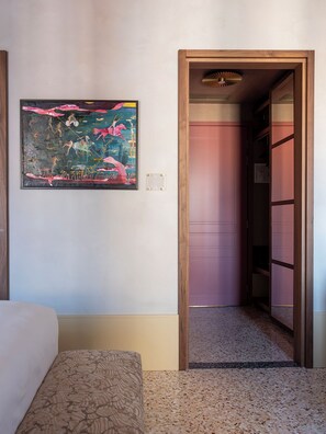 A hotel room with a bed, a painting on the wall, and a door leading to a hallway. -  Elizabeth Unique Venice a Member of Design Hotels (Venice)