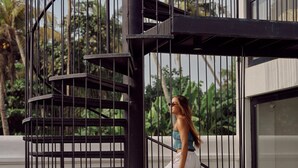 A spiral staircase with metal railings, surrounded by greenery and a building in the background. - UNU Boutique Hotel (Ahangama)