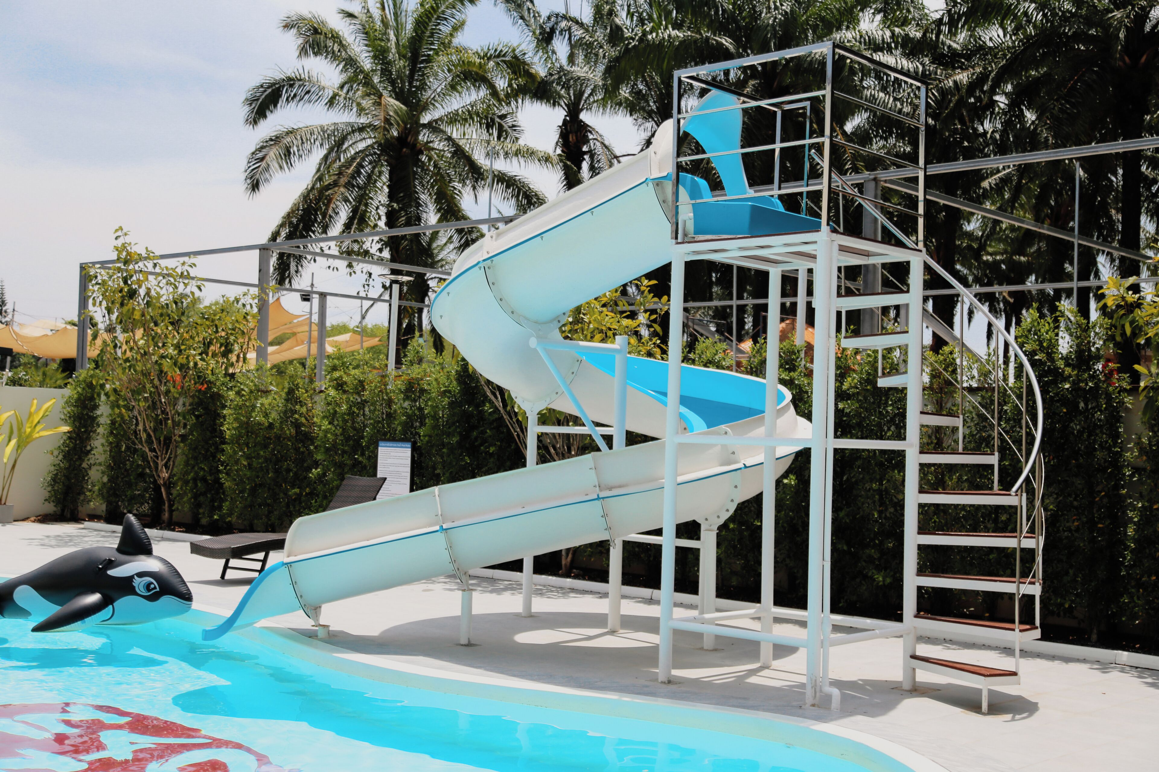 Estrutura de tobogã com piscina e um brinquedo flutuante em formato de golfinho.