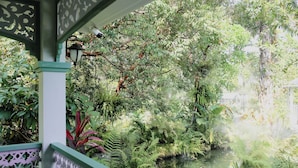 A lush garden with a pond, a table, and a lamp post. - Dinnano (Khlong Thom)