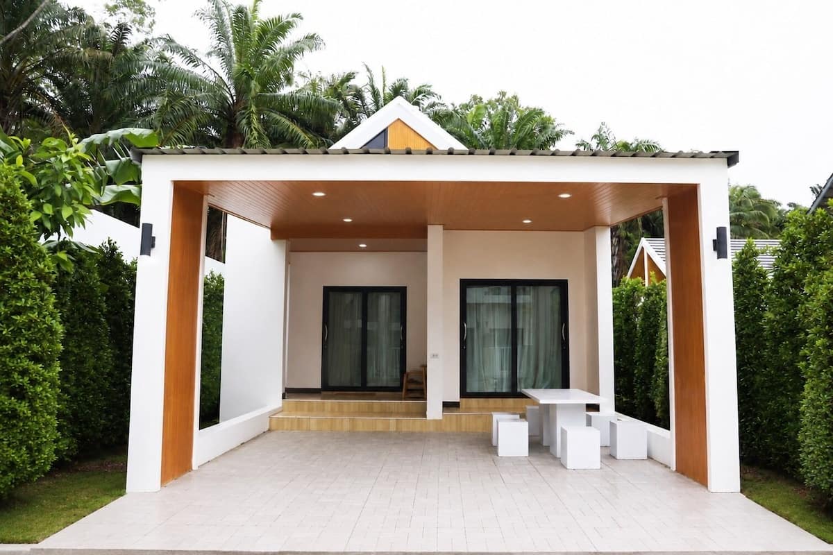 A modern house with a covered patio, large sliding glass doors, and a minimalist design.