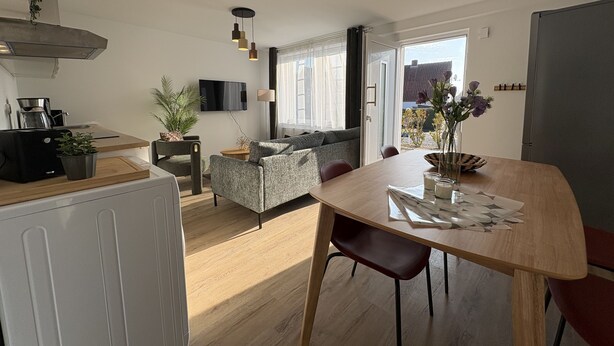 Een moderne keuken met een eethoek, een bank en een televisie.