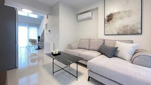 Ein modernes Wohnzimmer mit einer Couch, einem Couchtisch und einem großen abstrakten Gemälde an der Wand.