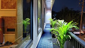 Un couloir avec des carreaux de sol décorés, des plantes en pot et un téléphone sur le côté gauche.