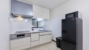 Una cocina moderna con microondas integrado, horno y lavavajillas, además de un refrigerador negro.
