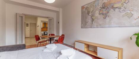 Een hotelkamer met een bed, een kaart aan de muur, een bureau en een stoel.