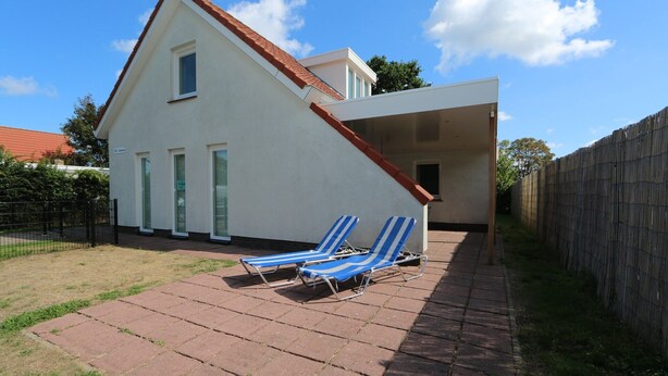 A two-story house with a sloped roof and a covered patio area. - Horizon 95 Comfortable villa with boxspring on vacation park (Renesse)